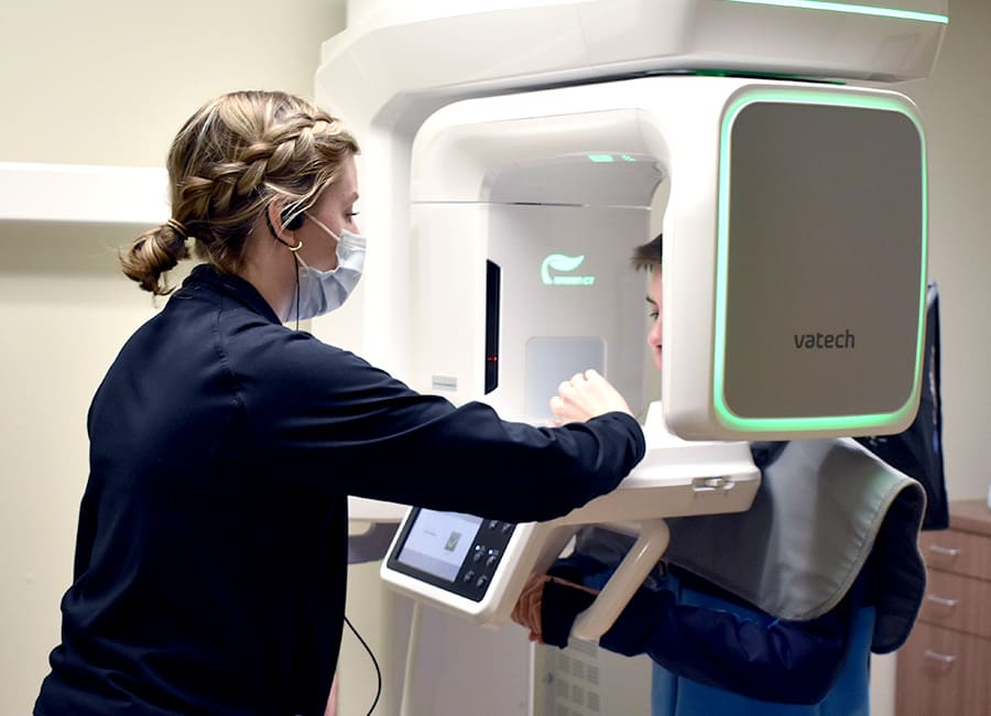 A dentist points to a panoramic X-ray.