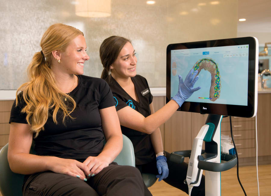 A team member at Munk Orthodontics shows a patient a 3D rendering of their teeth, creating using an iTero intraoral scanner.